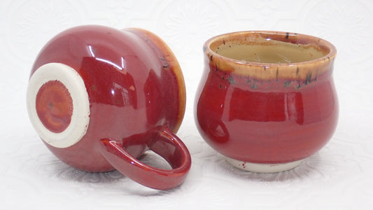 Two ceramic coffee mugs, stoneware coffee cups. Rustic red and cream glaze.